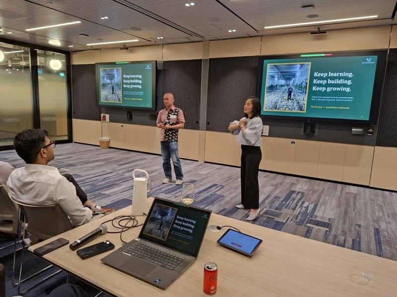 Raymond Cheung and co-presenter on stage with Keep Learning Keep Building Keep Growing slide